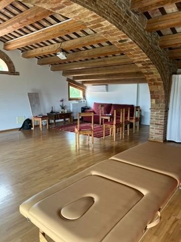 Sala de prácticas con arcos de piedra y vigas de madera
